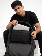 Laptop sliding into the padded laptop compartment of a Naught backpack